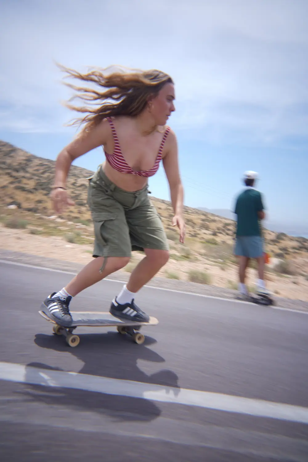 Carving the Coastal Road Woman carving on a surfskate along the coastal road above Imsouane, Morocco.